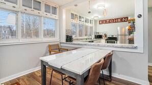 Una cocina moderna con un ventanal grande, una mesa de comedor con sillas y un letrero de cocina.