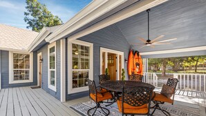 A covered outdoor patio with a round table and chairs, a ceiling fan, and a view of the surrounding area. - America's Lake Cabin with Patio & Firepit! (Nevada)