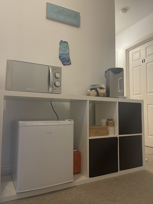 A kitchen area with a microwave, toaster, and refrigerator on a white countertop. - Valentia Skellig Rooms (Valentia Island)