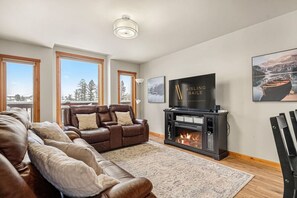 Smart-tv, eldstad och ett bordtennisbord