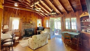 A rustic cabin interior with a fireplace, wooden furniture, and a dining area. - Breathtaking Private, Lakefront Retreat.  (Lebanon)