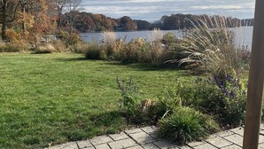 A paved walkway leading to a grassy area with a lake and trees in the background. - Breathtaking Private, Lakefront Retreat.  (Lebanon)