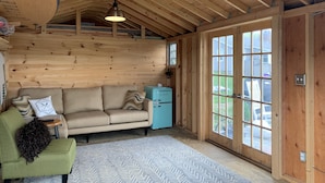 A cozy room with a wooden ceiling, a sofa, a small table, and a cabinet. - Breathtaking Private, Lakefront Retreat.  (Lebanon)
