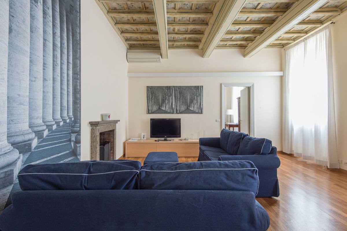 A living room with a fireplace, a TV, and a sofa set.