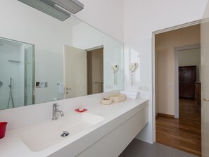 Luxe appartement | Badkamer | Een haardroger, een bidet, handdoeken, zeep