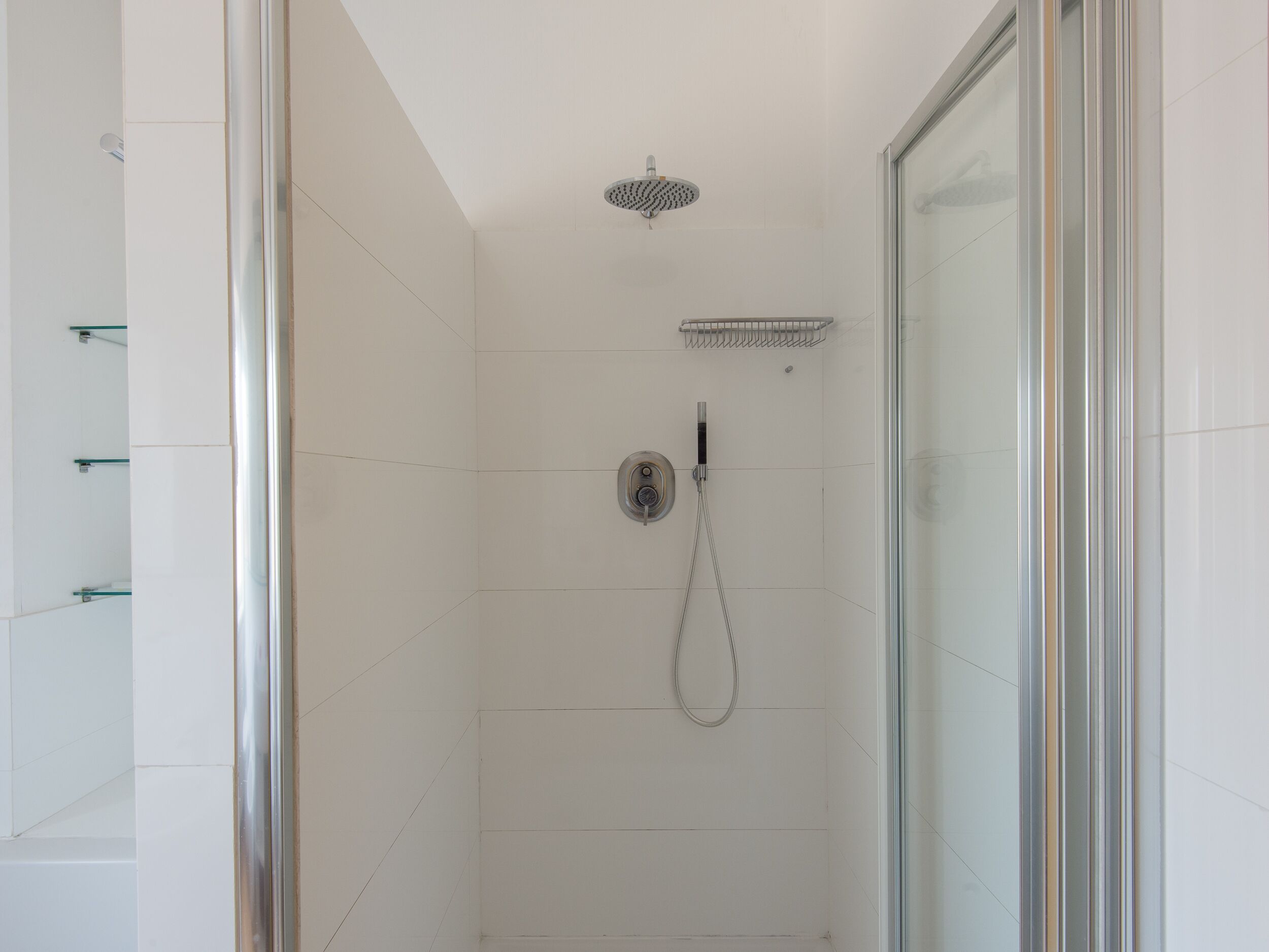 Eine moderne Dusche mit Handbrause und einer fest installierten Bedienung.