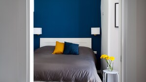 A bedroom with a bed, two bedside lamps, and a vase with flowers. - Manuela Apartments San Domenico Centro Storico (Napoli)