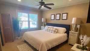 A bedroom with a bed, a ceiling fan, a window, a nightstand, and a bedside table. - Spacious one bedroom 2 miles from Texas Tech!

 (Lubbock)