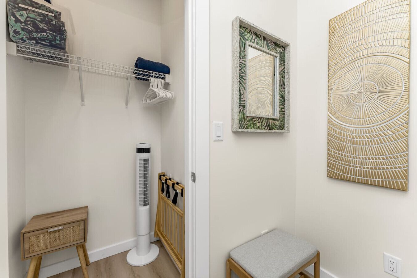 A bathroom with a white radiator, a wooden bench, a towel rack, and a mirror with a decorative frame.