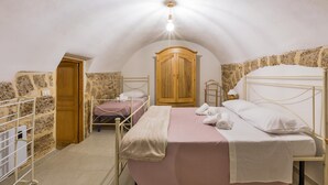 A bedroom with a single bed, a wooden wardrobe, a stone wall, and a small window. - 3693 Casa Relax by Barbarhouse (Mesagne)