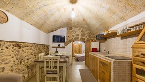 A rustic kitchen with stone walls, wooden cabinets, and a tiled backsplash. - 3693 Casa Relax by Barbarhouse (Mesagne)