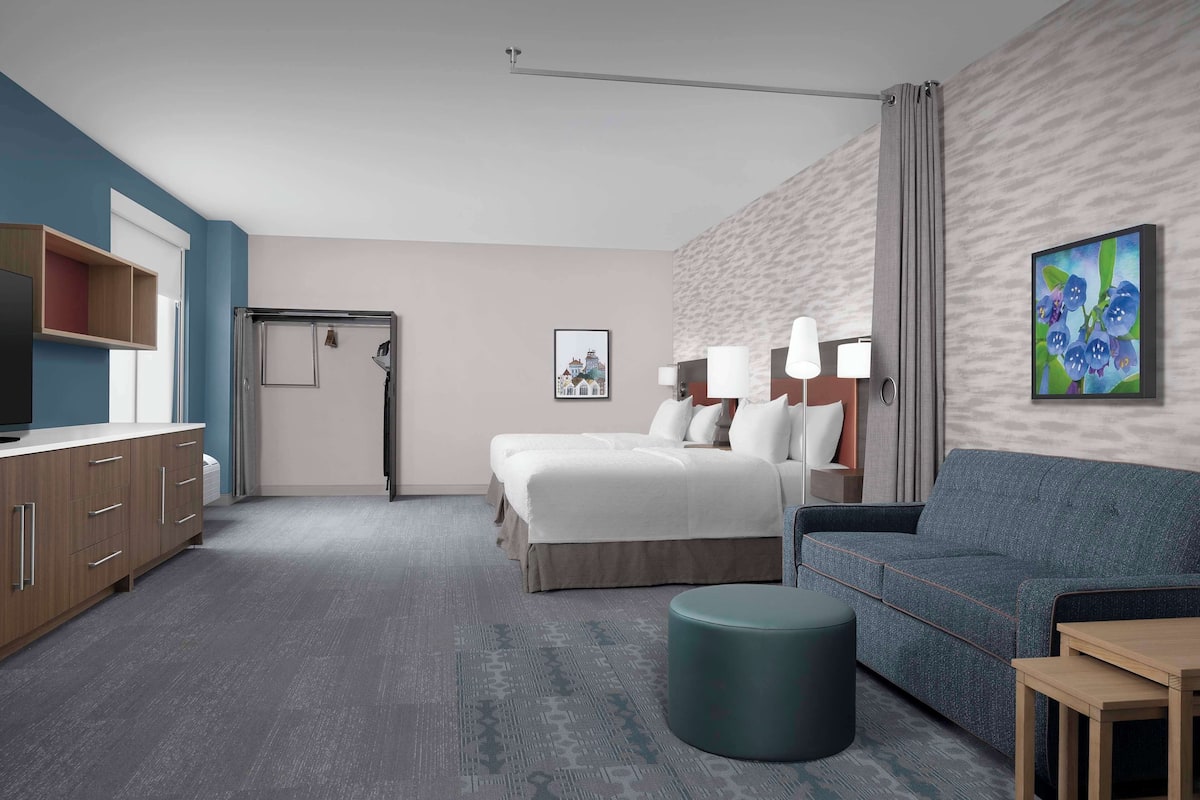 Une chambre d’hôtel comprenant un lit, un canapé, un bureau, une télévision et une salle de bain.