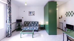 A living room with a sofa, a coffee table, a TV, and a fireplace. - VILL' ANDREA (App. 7) (Cecina)