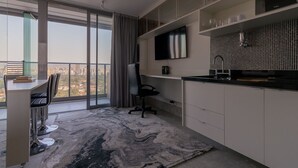 Een moderne keuken met een groot raam, een eethoek met uitzicht en een ingebouwde televisie.