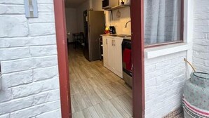 A narrow doorway leading into a kitchen with a refrigerator, microwave, and cabinets. - Cozy Suit!viajeros y Mujeres 100% Seguras!céntrico (Quito)