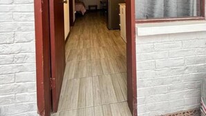 A narrow hallway leading to a bedroom with a bed and a small table. - Cozy Suit!viajeros y Mujeres 100% Seguras!céntrico (Quito)