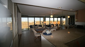 A spacious living area with a large window, a dining table, and a kitchen area. - New Listing...Beachfront Ground Floor - Steps to Beach, Unbelievable Views!!! (South Padre Island)