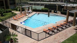 A rectangular swimming pool with a diving board, surrounded by a black metal fence. There are lounge chairs and a small inflatable pool on the pool deck. - New Listing...Beachfront Ground Floor - Steps to Beach, Unbelievable Views!!! (South Padre Island)