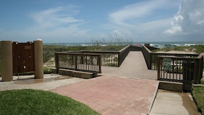 A wooden boardwalk leading to a beach with a dog waste sign. - New Listing...Beachfront Ground Floor - Steps to Beach, Unbelievable Views!!! (South Padre Island)