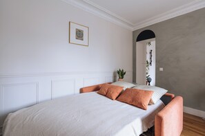 A bedroom with a bed, pillows, a bedside plant, and a mirror. - Unique & Luminueux - Appart 1 chambre- Montmartre! (Paris)