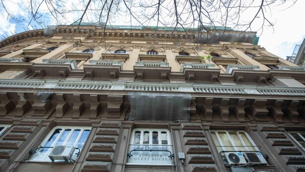 Fachada de edificio con un letrero que dice 'Lado Diamond Superior Guest House'.