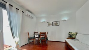A room with a dining table and chairs, a sofa, and a bed. - 1bedroom duplex beach apartment (Carvoeiro)