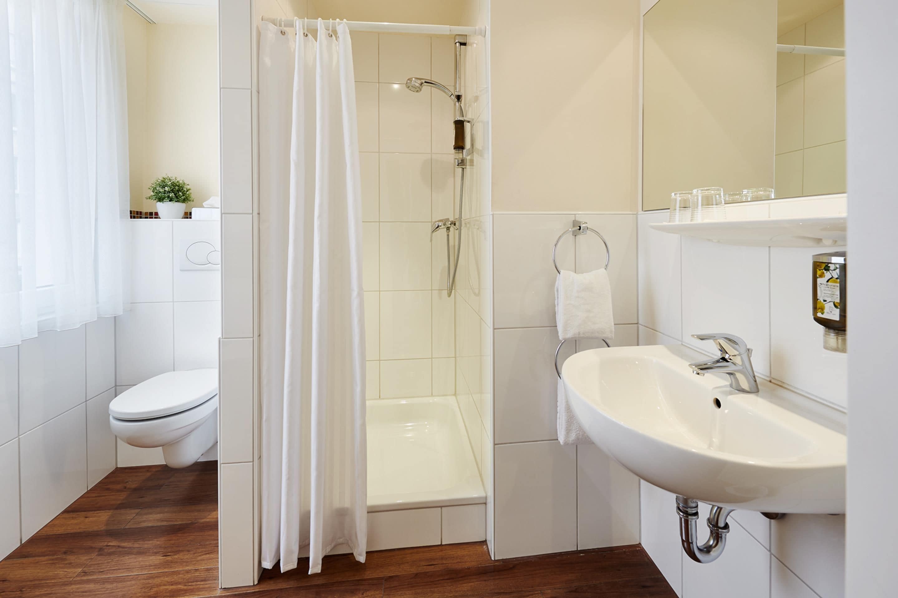 Une salle de bain moderne équipée d’une douche, de toilettes et d’un lavabo.