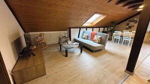 A loft-style room with a wooden ceiling, a sofa, a coffee table, and a dining area with chairs. - Schöne, Geräumige Ferienwohnung im Wein- u. Wandergebiet, Freizeitpark I.d. Nähe (Löchgau)