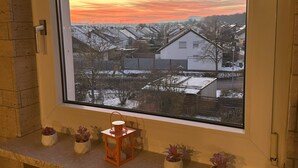 A window with a view of a snowy landscape and houses during sunset. - Schöne, Geräumige Ferienwohnung im Wein- u. Wandergebiet, Freizeitpark I.d. Nähe (Löchgau)