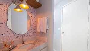 Une salle de bain avec un double vasque, un grand miroir et une serviette accrochée au mur.