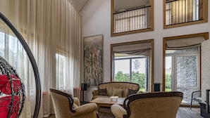 Ein geräumiges Wohnzimmer mit großem Fenster, einem Essbereich mit Tisch und Stühlen und Blick ins Freie.
