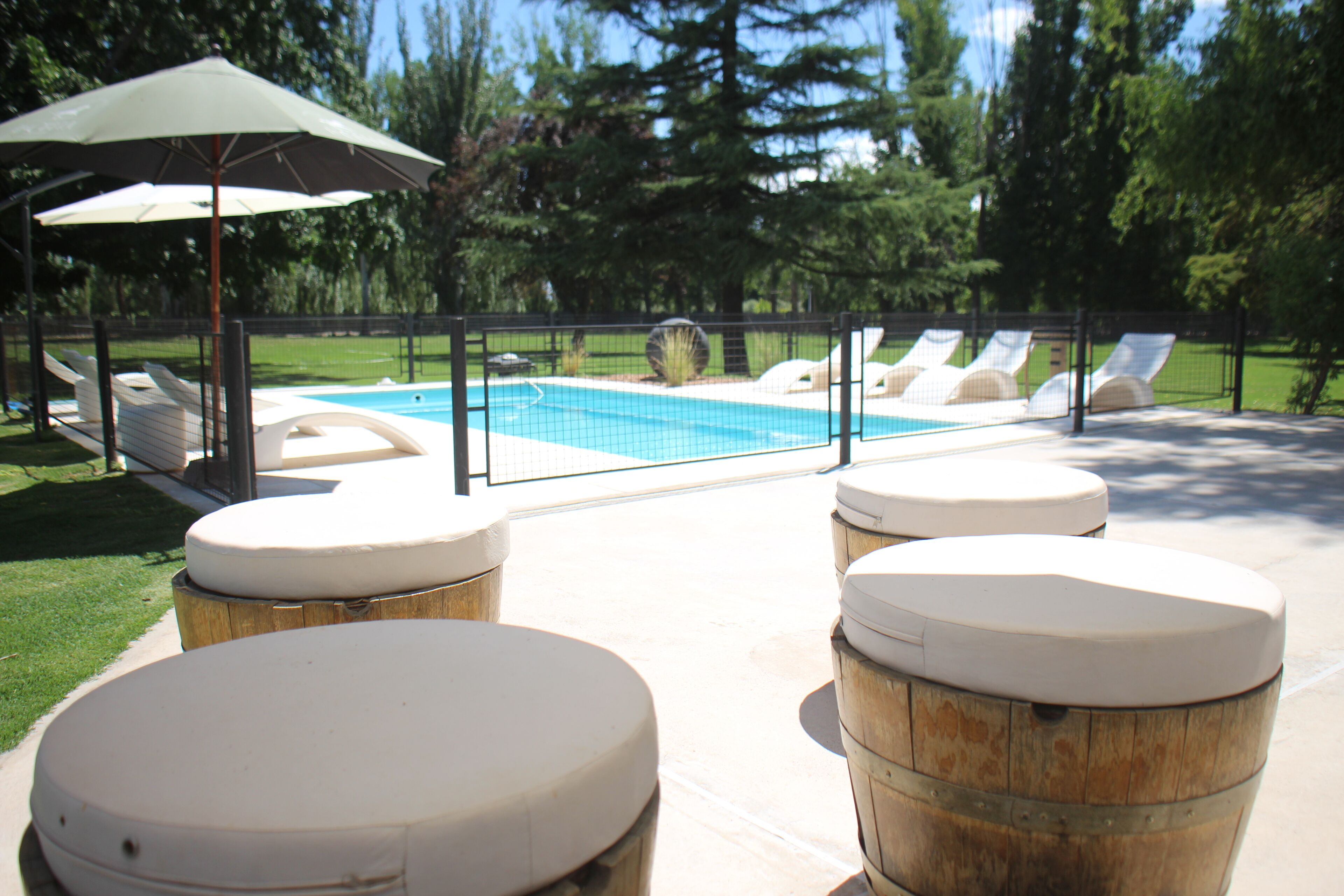Una piscina al aire libre de temporada, sombrillas
