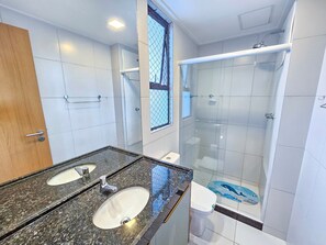 A bathroom with two sinks, a shower, and a toilet. - Makia Beach Experience (Ipojuca)