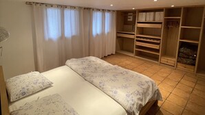 A bedroom with a double bed, a wardrobe, and a built-in closet.