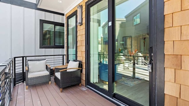 A balcony with wicker furniture and a sliding glass door. - Paradise at The Cove Riverwalk Villas (Wilmington)