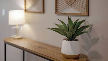 A potted plant on a wooden table with a lamp in the background.