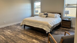 A bedroom with a bed, wooden flooring, a ceiling fan, and two windows. - Modern Mesquite New Home perfect for golfers and families alike. (Mesquite)