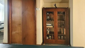 Una puerta de madera y un aparador con frentes de vidrio y estantes.