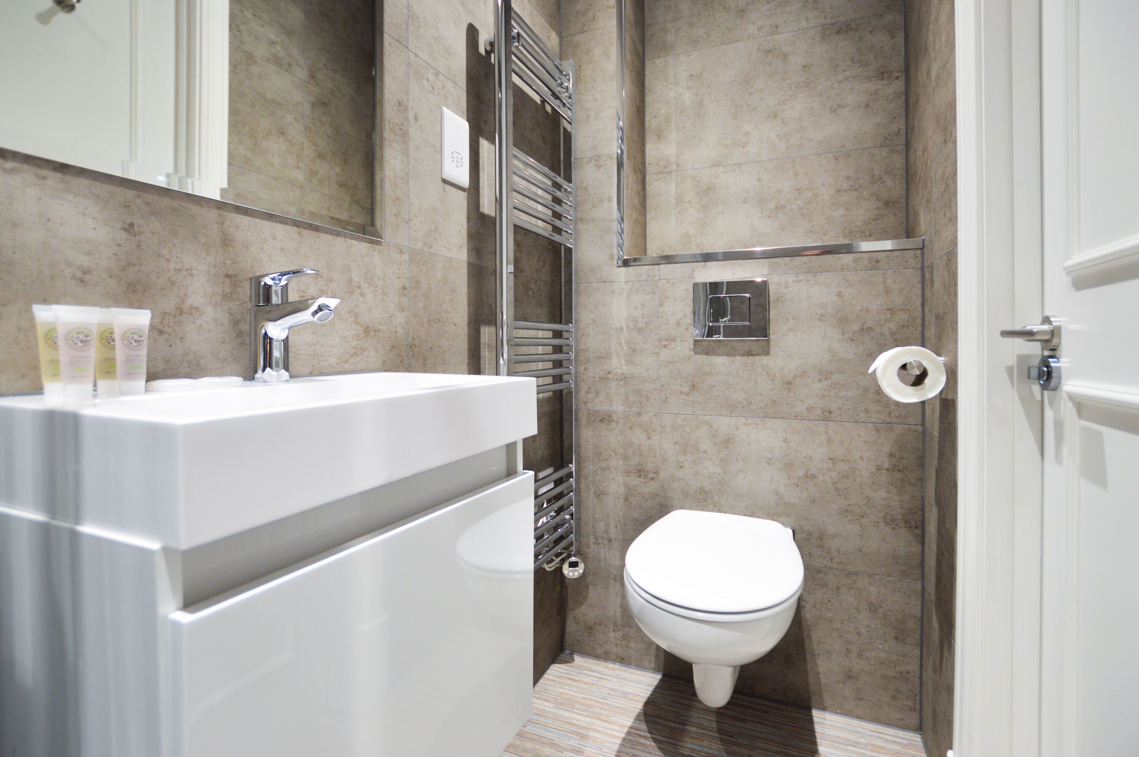 Ein modernes Badezimmer mit Waschbecken, Armatur aus Chrom und Toilette.