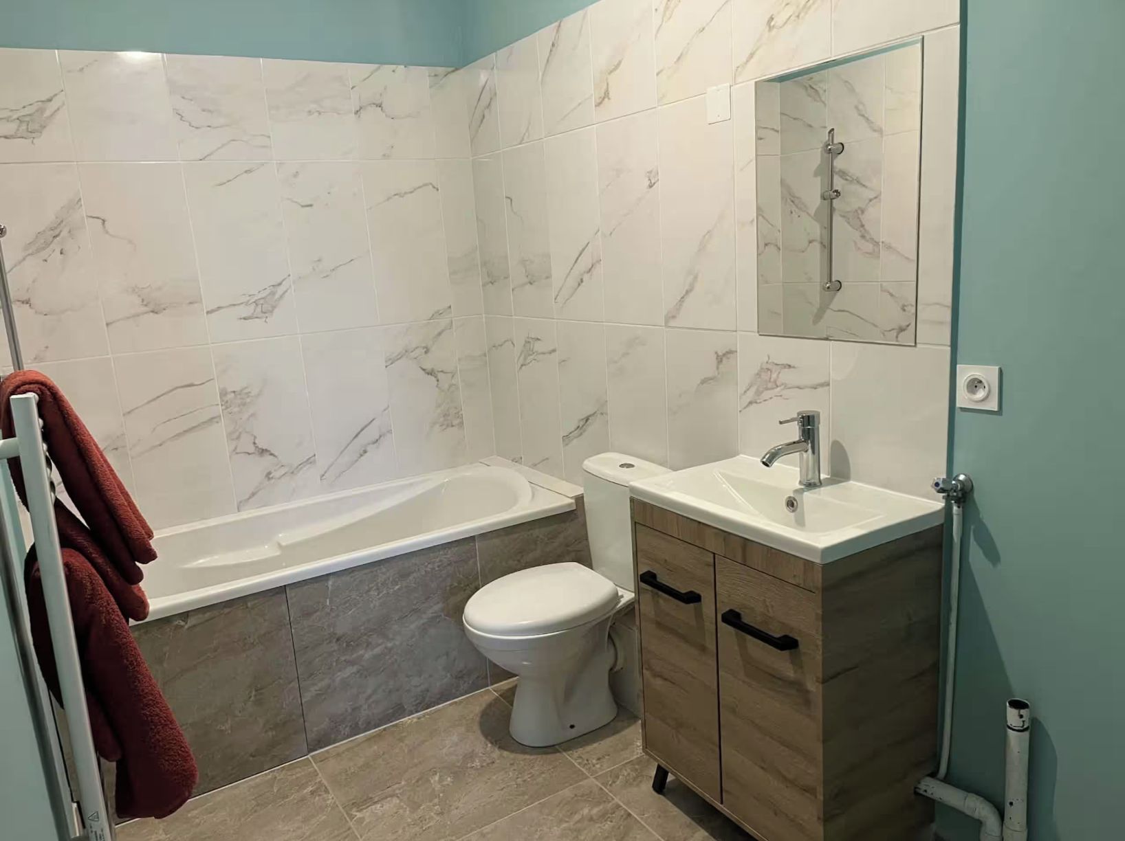 A bathroom with a bathtub, toilet, and vanity.