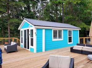 Situated on a wooden deck, this charming building offers a tranquil setting surrounded by trees.