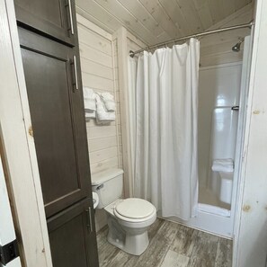Bathroom features a toilet, sink, and shower area.