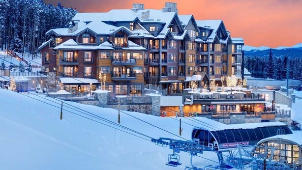 A multi-story lodge with a ski lift in the foreground, surrounded by snow-covered trees and mountains. - Ski In/Out! Easy Access-1 Bedroom Breckenridge Master-1.5 Baths-Sleeps 4 (Breckenridge)