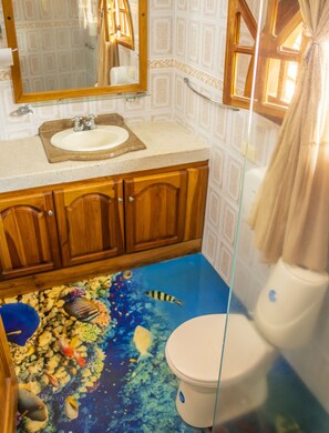 A bathroom with a sink, mirror, wooden cabinets, and a toilet. - hostal san jorge (Pereira)