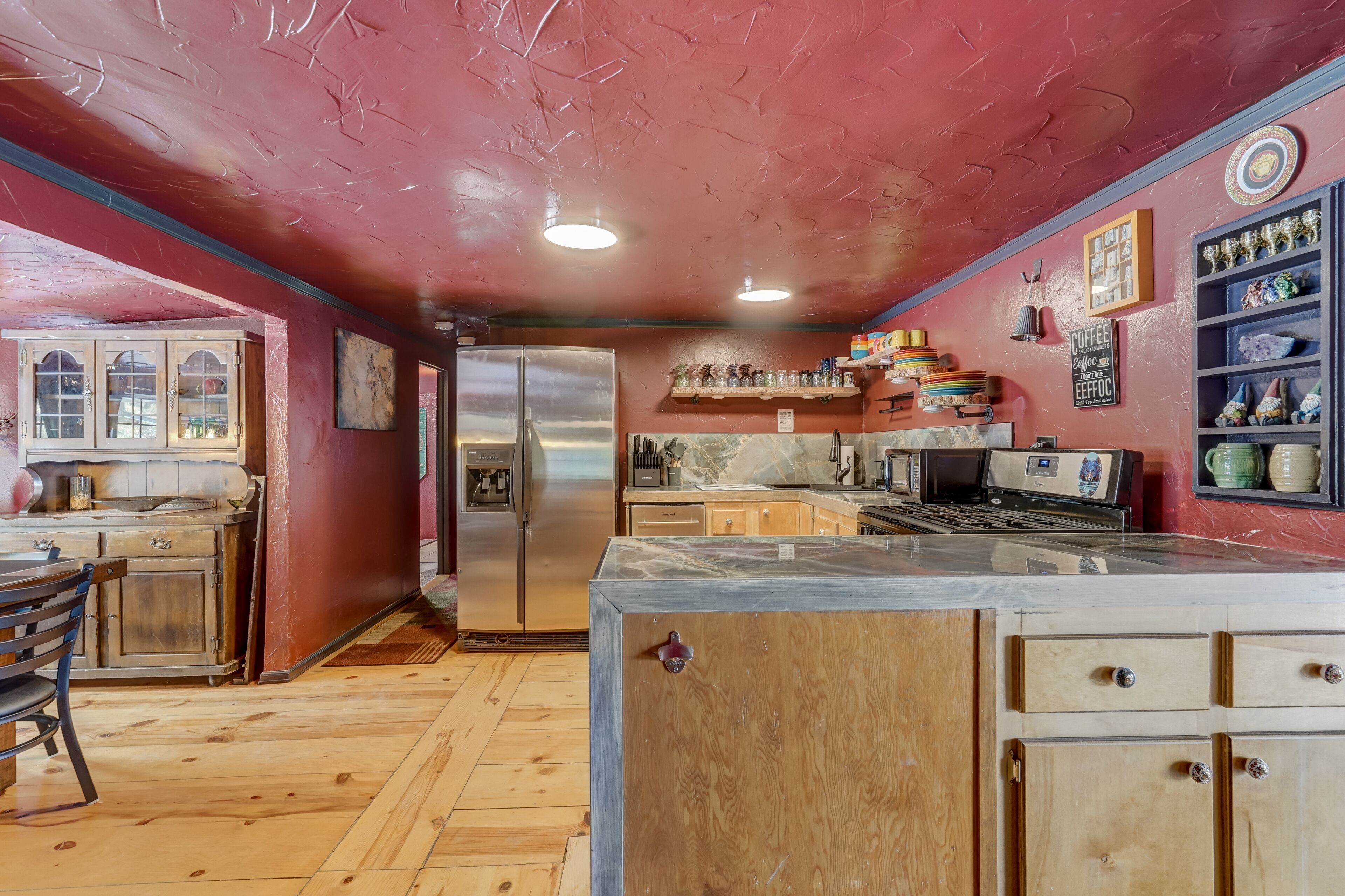 A kitchen with wooden cabinets, a refrigerator, and a coffee station.