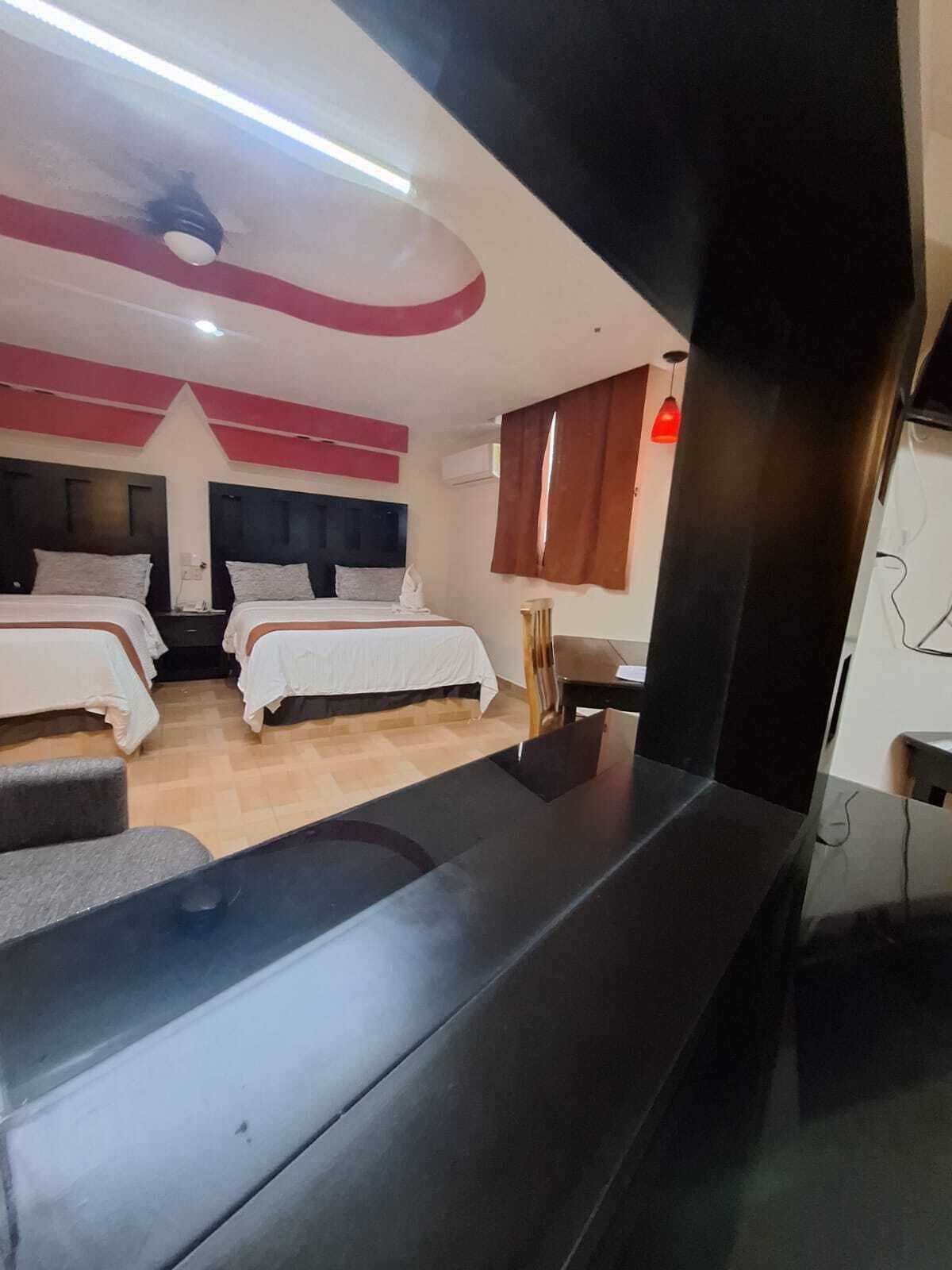 Una habitación de hotel con dos camas, un escritorio y un televisor.