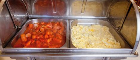 Un buffet con due sezioni: una con salsa rossa e carote, e un'altra con uova strapazzate.