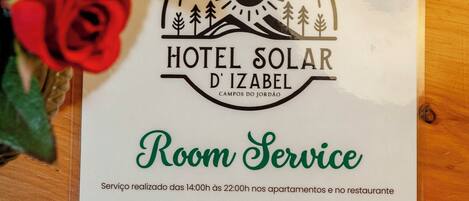 A hotel service sign for Hotel Solar D'Izabel, indicating room service availability from 14:00 to 22:00 in apartments and the restaurant.