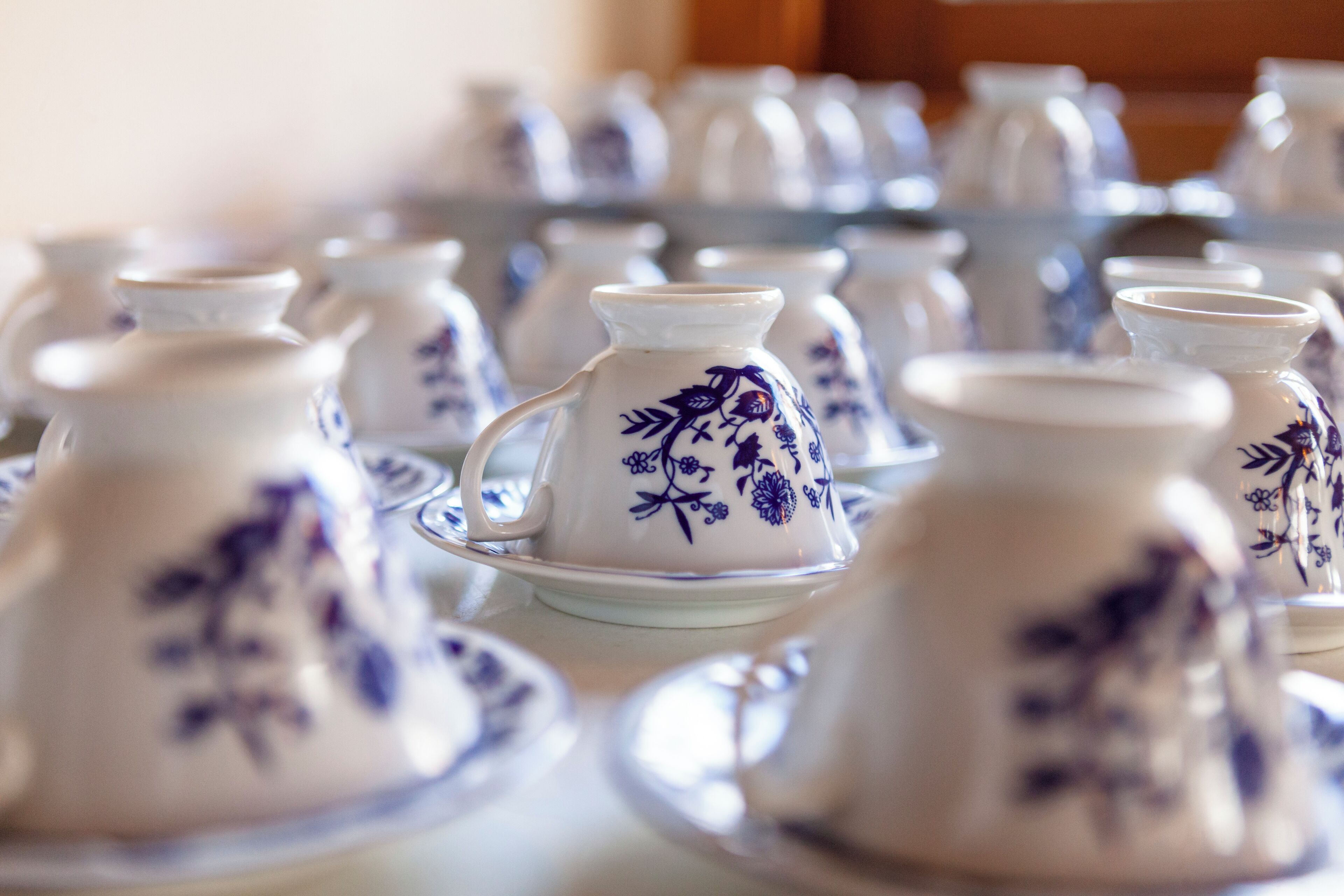 Un conjunto de jarrones de cerámica blanca con diseños florales azules, colocados sobre una mesa.