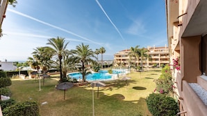 Un hotel con piscina, palmeras y cielo despejado.